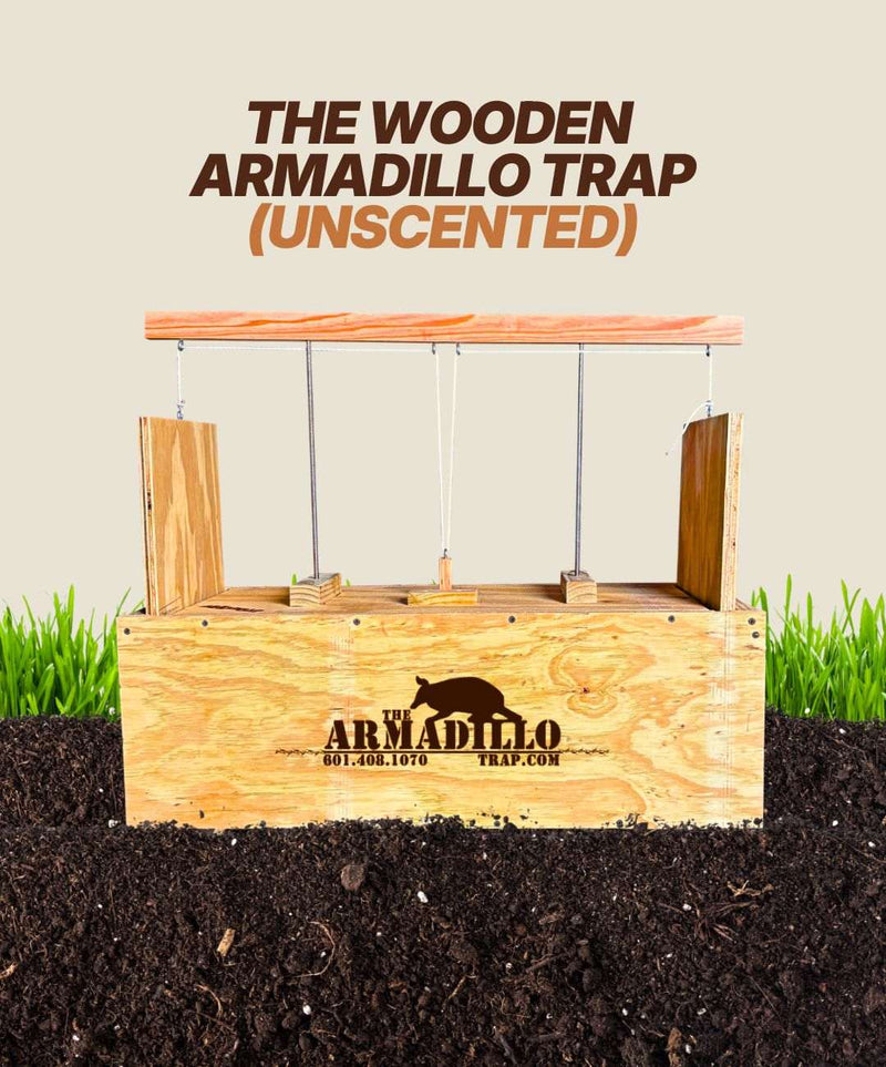 An Unscented Wooden Armadillo Trap by Armadillo Trap, featuring a logo and contact info, rests on soil before green grass. Bold text above says, "UNSCENTED WOODEN ARMADILLO TRAP," ideal for effective armadillo control or expert guidance.